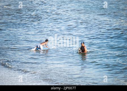 Salvador, Bahia, Brasilien - 01. November 2021: Surfer, der in das Wasser des Rio Vermelho Strandes in Salvador, Bahia, eindringt. Stockfoto