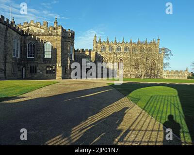 Lange Schatten von Figuren Tore & gewölbter Eingang auf Rasen & Wege führt zum stattlichen Bishop's Palace, Bishop Auckland, County Durham, England UK Stockfoto