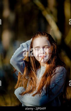 Porträt eines langhaarigen rothaarigen Mädchens im Park. Stockfoto