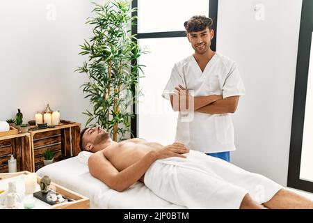 Zwei hispanische Männer Therapeuten und Patienten mit Beauty-Session im Beauty-Center Stockfoto