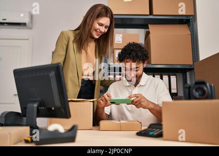 Mann und Frau Geschäftsleute machen Fotos, um im Büro zu verpacken Stockfoto