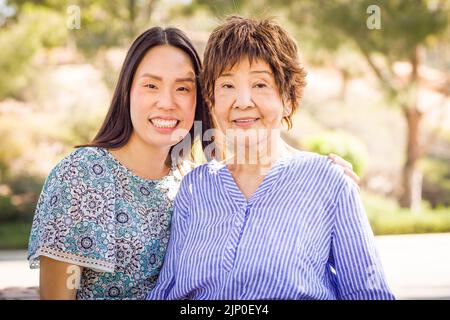 Außenportrait einer glücklichen chinesischen Mutter und Tochter. Stockfoto