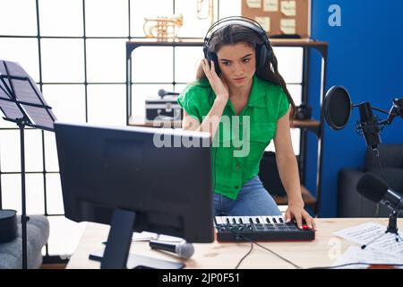 Junge hispanische Musikerin mit dj-Session im Musikstudio Stockfoto