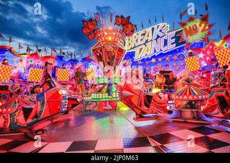 Herne, NRW, Deutschland. 14. August 2022. Die Break Dance Ride erweist sich als beliebt.Cranger Kirmes, Deutschlands 3. größte Jahrmarktmesse mit einer Tradition aus dem Mittelalter, ist mit mehr als 3,9m Besuchern bei heißem, sonnigem Wetter wieder auf die pandemische Besucherzahl zurückgekehrt, die Fahrten, Achterbahnen, Bierhallen, Essen und Trinken. Der Jahrmarkt endete heute Abend mit einem Feuerwerk über dem nahe gelegenen Rhein-Herne-Kanal. Kredit: Imageplotter/Alamy Live Nachrichten Stockfoto