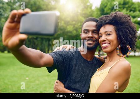 Bilder im Park. Ein liebevolles junges Paar, das Selfies macht, während es einige Zeit im Park verbringt. Stockfoto