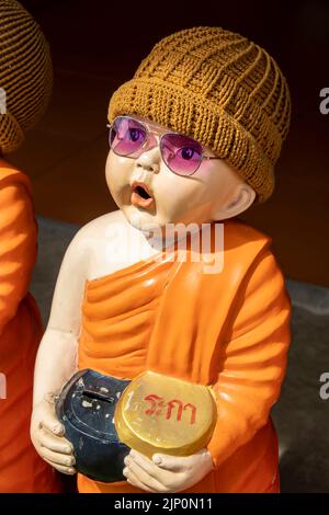 Chachoengsao Thailand : die Statue eines niedlichen jungen Mönchs mit Sonnenglas und Strumpfkappe in Wat Saman Rattanaram, der für rosa Ganesha berühmt ist Stockfoto