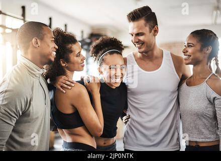 Kein Kumpel wie ein Kumpel im Fitnessstudio. Eine Gruppe glücklicher junger Menschen, die gemeinsam in einem Fitnessstudio trainieren. Stockfoto