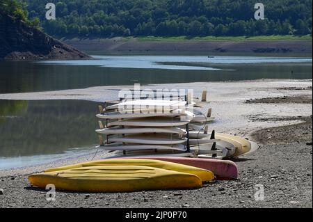 Bringhausen, Deutschland. 11. August 2022. Surfbretter und Kajaks sind in Bringhäuser Bay trocken. Das größte Hessische Reservoir ist aufgrund der Dürre und der Wasserabgabe an die Weser-Navigation nur zu 20 Prozent voll. Quelle: Uwe Zucchi/dpa/Alamy Live News Stockfoto