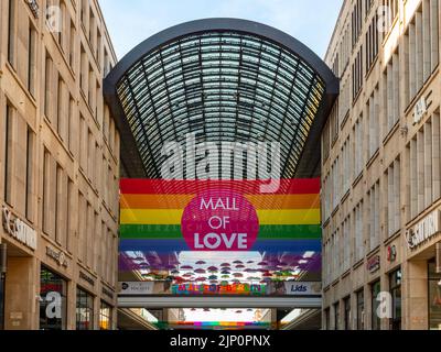 Einkaufszentrum Mall of Berlin mit einem riesigen LGBTQ-Banner. Ein weltweites Symbol für Toleranz und Respekt vor Menschen. Die berühmte Regenbogenfahne in der Öffentlichkeit. Stockfoto