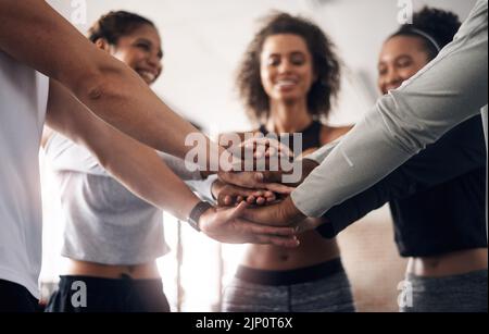 Gesundheit ist jedermanns Verantwortung. Eine Gruppe junger Menschen verbindet sich solidarisch in einem Fitnessstudio. Stockfoto