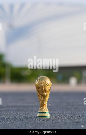 DOHA, KATAR - 14. AUGUST 2022: Trophäe der FIFA-Weltmeisterschaft vor dem Hintergrund des Al Janoub-Stadions in Katar. Stockfoto