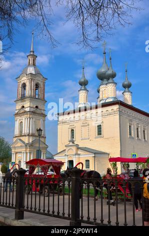 Susdal, Russland, 05.08.2022. Smolensk Kirche mit einem Glockenturm. Touristische Pferdekutschen am Denkmal der russischen Architektur des XVII. Jahrhunderts Stockfoto
