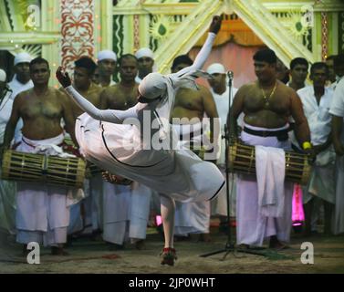 Colombo, Sri Lanka. 13. August 2022. Eine traditionelle srilankische Tänzerin tritt während der traditionellen Zeremonie „Gammaduwa“ am 13. August 2022 im Dorf Nawagamuwa in der Nähe von Colombo auf. Unter den Yatukarma, die in den niederen Gebieten Sri Lankas abgehalten werden, ist das Gammaduwa Shanthikarma ein großes Yatukarma, das auf die Prävention von Krankheiten und Fruchtbarkeit der Singhalesen abzielt. Gammaduwa Shanthikarma begann im Gebiet von Ruwanwella als „Devol Maduwa“ für ein Handwerk zur Prävention von Krankheiten. Es ist das Haupt Shanthikarma der niedrigen Landtanz-Tradition geworden, die aus den drei Haupttanz-Traditionen von Matara besteht, gebogen Stockfoto