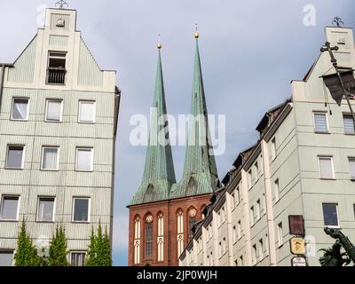 St. Nicholk Kirche hinter alten Gebäuden im berühmten St. Nicholk Viertel. Ein Reiseziel für viele Touristen in der Hauptstadt Deutschland. Stockfoto