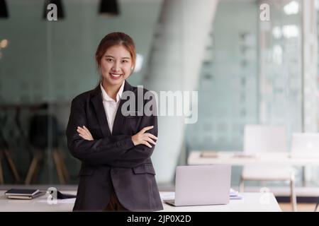 Schöne junge asiatische Geschäftsfrau im Büro Stockfoto