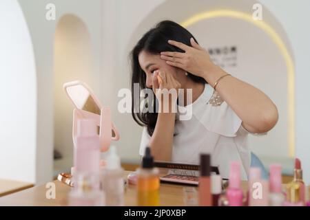 Frau mit Kosmetik und versuchen, sich nach ihrem Vlogger zu bilden Stockfoto