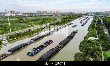 HUAI'AN, CHINA - 14. AUGUST 2022 - Frachtschiffe fahren zum und vom Großen Kanal von Peking-Hangzhou (Huai 'an Abschnitt), um die Versorgung mit Transpo zu gewährleisten Stockfoto