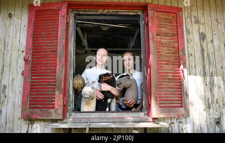 Stuttgart, Deutschland. 26.. Juli 2022. Arwen (l) und Marie stehen mit ihren Hobbypferden in einem Stall im Garten. Sie üben den Sport Hobby Horsing. Quelle: Bernd Weißbrod/dpa/Alamy Live News Stockfoto