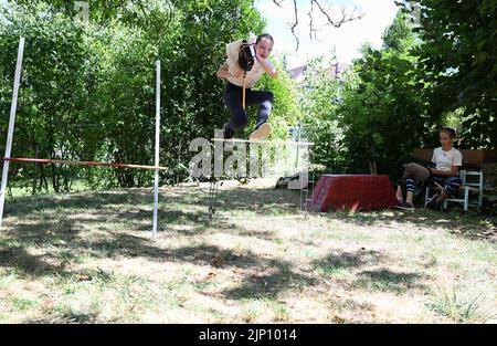 Stuttgart, Deutschland. 26.. Juli 2022. Arwen springt mit ihrem Hobbypferd in einem Garten auf einen Hindernisparcours. Sie übt den Sport des Hobbyhorsens aus. (To dpa: 'Arwens Hobbypferde sind Hobbypferde') Quelle: Bernd Weißbrod/dpa/Alamy Live News Stockfoto