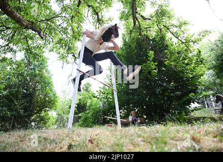 Stuttgart, Deutschland. 26.. Juli 2022. Arwen springt mit ihrem Hobbypferd in einem Garten auf einen Hindernisparcours. Sie übt den Sport des Hobbyhorsens aus. (To dpa: 'Arwens Hobbypferde sind Hobbypferde') Quelle: Bernd Weißbrod/dpa/Alamy Live News Stockfoto