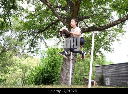 Stuttgart, Deutschland. 26.. Juli 2022. Arwen springt mit ihrem Hobbypferd in einem Garten auf einen Hindernisparcours. Sie übt den Sport des Hobbyhorsens aus. (To dpa: 'Arwens Hobbypferde sind Hobbypferde') Quelle: Bernd Weißbrod/dpa/Alamy Live News Stockfoto