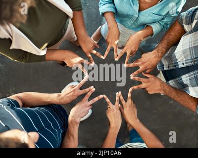 Sehen wir uns an, was es bedeutet, ein Team zu sein. In einem hohen Winkel eine nicht erkennbare Gruppe von Arbeitskollegen, die mit ihren Fingern eine einzigartige Gruppe bilden Stockfoto