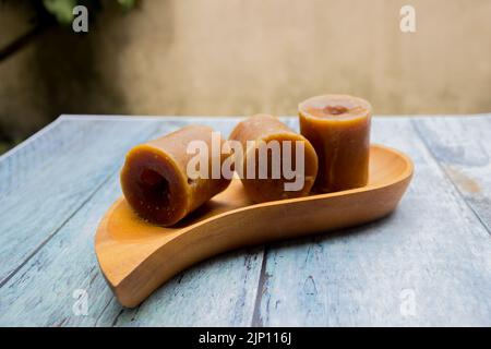 Indonesischer brauner Zucker, Palmzucker oder gula merah in Würfeln mit Holzschale Stockfoto