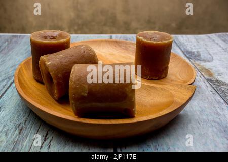 Indonesischer brauner Zucker, Palmzucker oder gula merah in Würfeln mit Holzschale Stockfoto