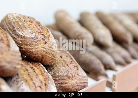 Brotlaibe auf Regalen in einer Bäckerei. Selektiver Fokus. Stockfoto