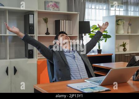 Entspannte Person Geschäftsmann Porträt lächelnd im Stuhl nach Online-Arbeit im Büro Arbeit mit Laptop-Profi auf dem Schreibtisch modernen Arbeitsplatz Netzwerk Ziffer Stockfoto