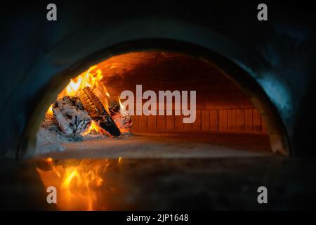 Pizza backen im Backofen offen Brennholz Stockfoto