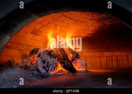 Pizza backen im Backofen offen Brennholz Stockfoto