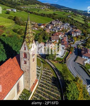 Villandro, Italien - Luftaufnahme des Turms der Kirche St. Michael im kleinen Dorf Villanders an einem sonnigen Sommertag mit Blau Stockfoto