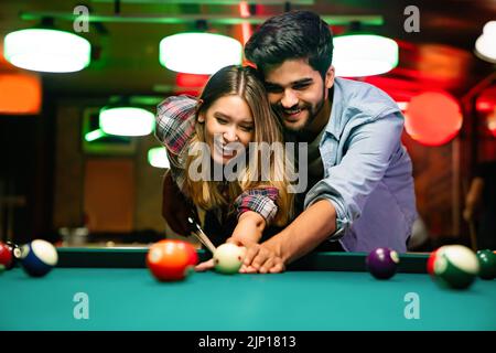 Paar dating, flirten und spielen Billard in einem Pub Stockfoto