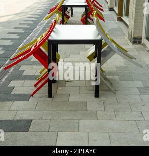 Esstische und Stühle im Freien in der Stadtstraße Stockfoto