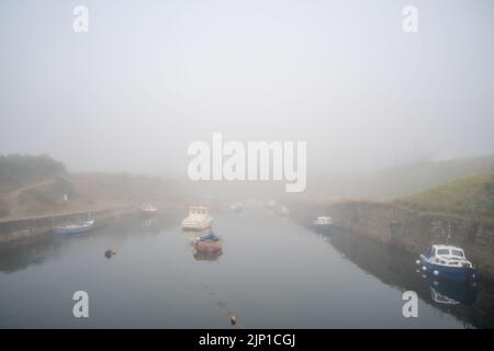 Boote in schwerem Meer stürzen am Hafen bei Flut in Seaton Sluice, Northumberland, Großbritannien, am 14. August 2022. Stockfoto