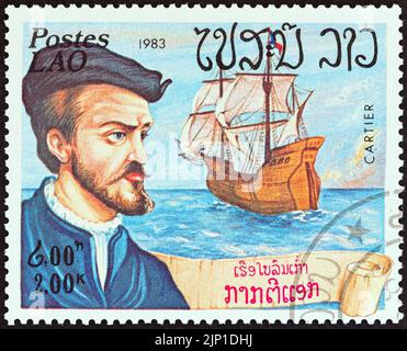 LAOS - UM 1983: Eine in Laos gedruckte Briefmarke aus der Ausgabe 'Explorers and their Ships' zeigt Jacques Cartier und Grande Hermine, um 1983. Stockfoto