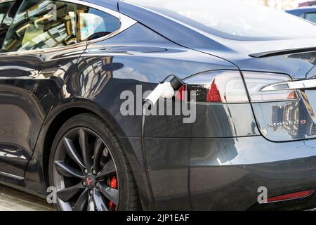 Minsk, Weißrussland - 12. August 2022: Tesla-Auto lädt den Elektromotor an der Ladestation auf der Straße. Elektroautos, Ökologie, Transportkonzept. Hochwertige Fotos Stockfoto