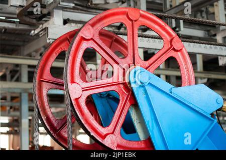 Große Metallrolle mit gestrecktem Metallseil, Teil eines Aufzugs Stockfoto