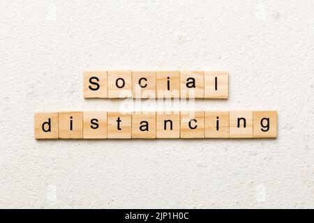 Soziale Distanzierung Wort auf Holzblock geschrieben. Soziale Distanzierung Text auf Zementtisch für Ihr Design, Konzept. Stockfoto
