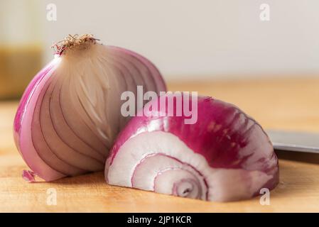 Olivenöl, rote Zwiebeln, Senf mit einem Löffel in einer Schüssel gemischt und Glas Vorbereitung für einen Bohnensalat Stockfoto