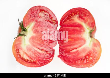 Eine große rote reife Tomate in zwei Hälften geschnitten Stockfoto
