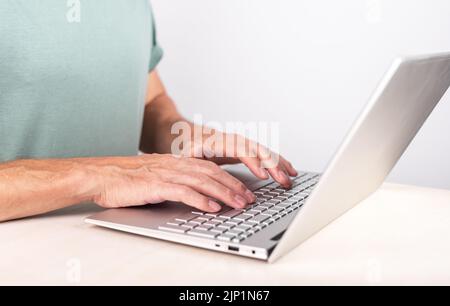 Mann Hände Nahaufnahme tippen auf Laptop-Tastatur. Computer für Arbeit, Studium verwenden. Freiberuflicher Lebensstil. Am Schreibtisch sitzender Mann. Hochwertige Fotos Stockfoto