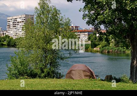 Frühfrühling mit frischen Bäumen und einer Wiese mit Zelt am Seeufer im Wohnviertel Drujba, Sofia, Bulgarien Stockfoto