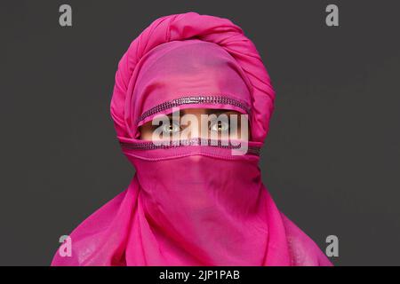 Nahaufnahme einer jungen, charmanten Frau, die den pinken Hijab trägt, der mit Pailletten verziert ist. Arabischer Stil. Stockfoto