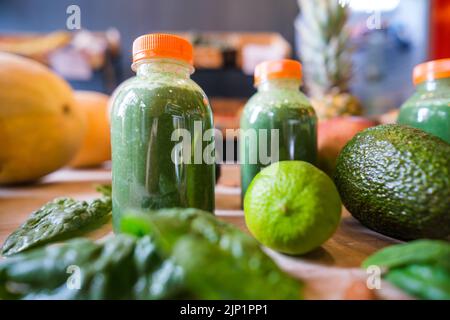 Gesunde Protein-Shake auf dem Tisch mit Obst und Gemüse Zutaten herum. Stockfoto