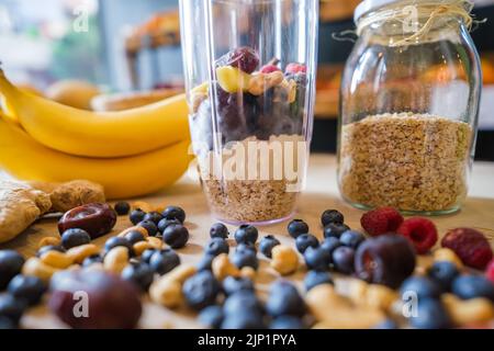 Gesunde Protein-Shake auf dem Tisch mit Obst und Gemüse Zutaten herum. Stockfoto