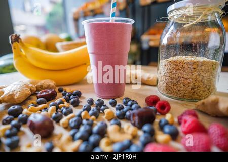 Gesunde Protein-Shake auf dem Tisch mit Obst und Gemüse Zutaten herum. Stockfoto