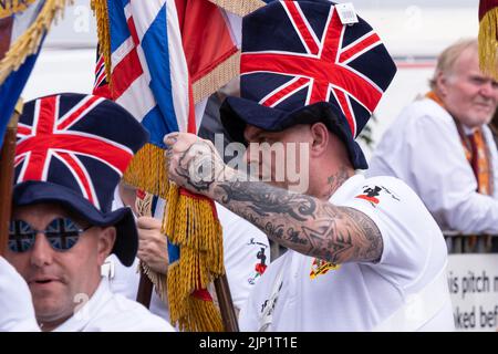 Ballymena, Großbritannien. 12. Juli 2022. Mitglieder der Ballymena Proddy Boys Flötenband tragen Union Jack Hüte und verlassen das Versammlungsfeld in Ballee Stockfoto