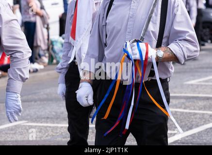 Ballymena, Großbritannien. 12. Juli 2022. Loyaler Bandsman mit zeremoniellem Schwert, das mit bunten Bändern geschmückt ist. Stockfoto